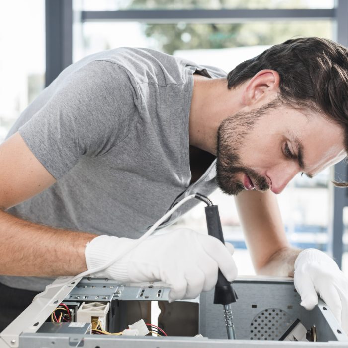 side-view-young-male-technician-working-broken-computer